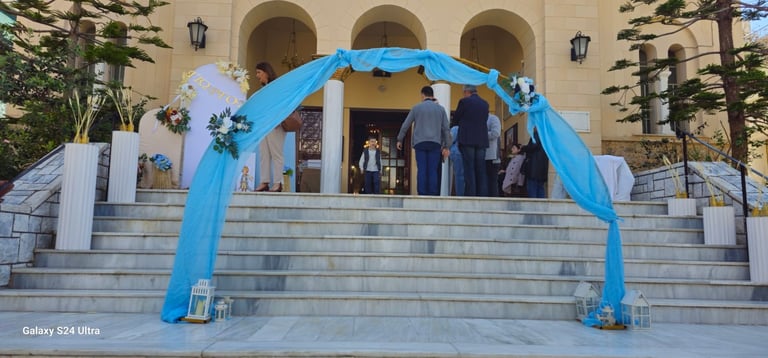 Μπλε αψίδα διακόσμησης σε πέτρινα σκαλιά μπεζ κτιρίου με κόσμο κάτω από κλασικές αψίδες